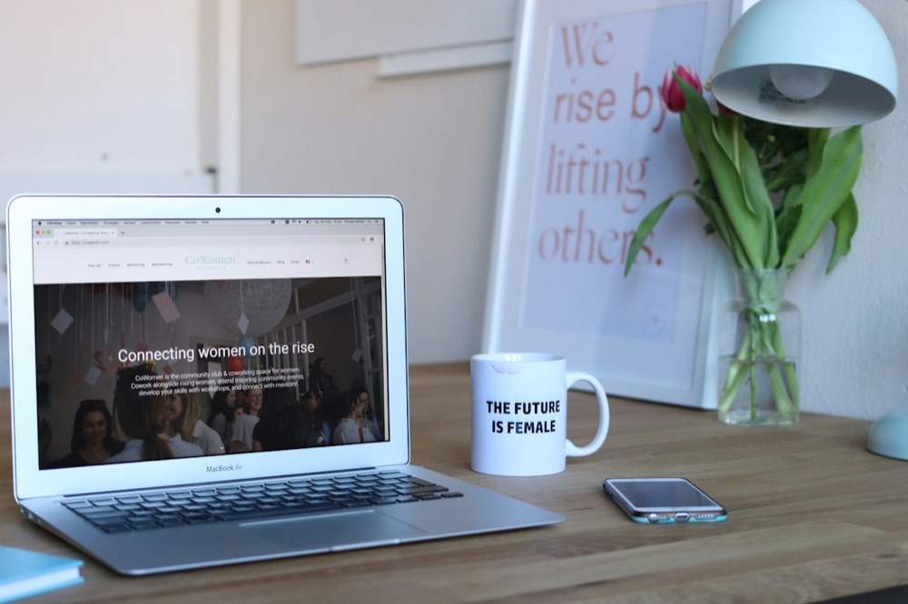 Bureau d'entrepreneure : ordinateur, tasse « The future is female » et tulipes